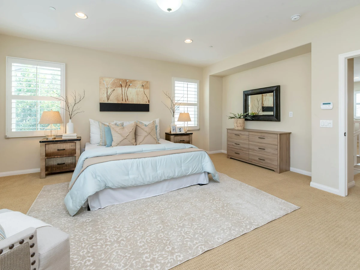 bedroom-painting-spacious-bright-bedroom-barnstaple-decorators A bright bedroom with a bed, bedside tables and a rug