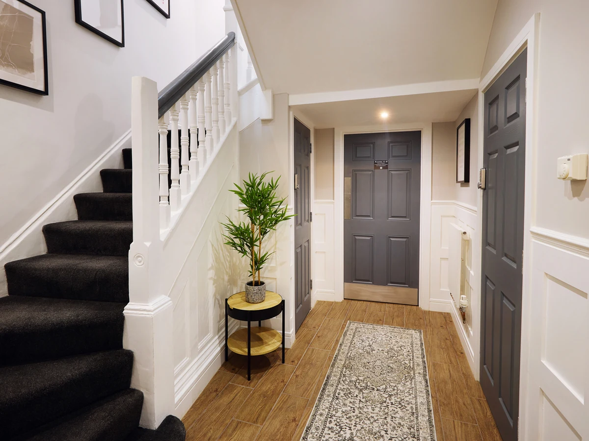 hallway-painting-modern-hallway-white-barnstaple-decorators A hallway with a staircase, white banister and a dark front door