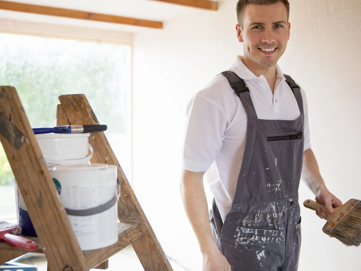 Decorator with brush on ladder working in Barnstaple